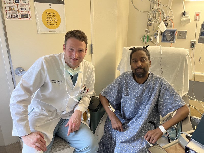 Heart surgeon Tyler Gunn, MD, director of the Extracorporeal Membrane Oxygenation Program at Cedars-Sinai sits on the bed of patient Valance Sams Sr., who received a heart, liver and kidney transplant during a 20-hour surgery at Cedars-Sinai Medical Center.