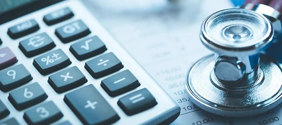 CFPB finalizes rule banning inclusion of medical debt on credit reports. A calculator, a stethoscope, and a credit report on a desk.
